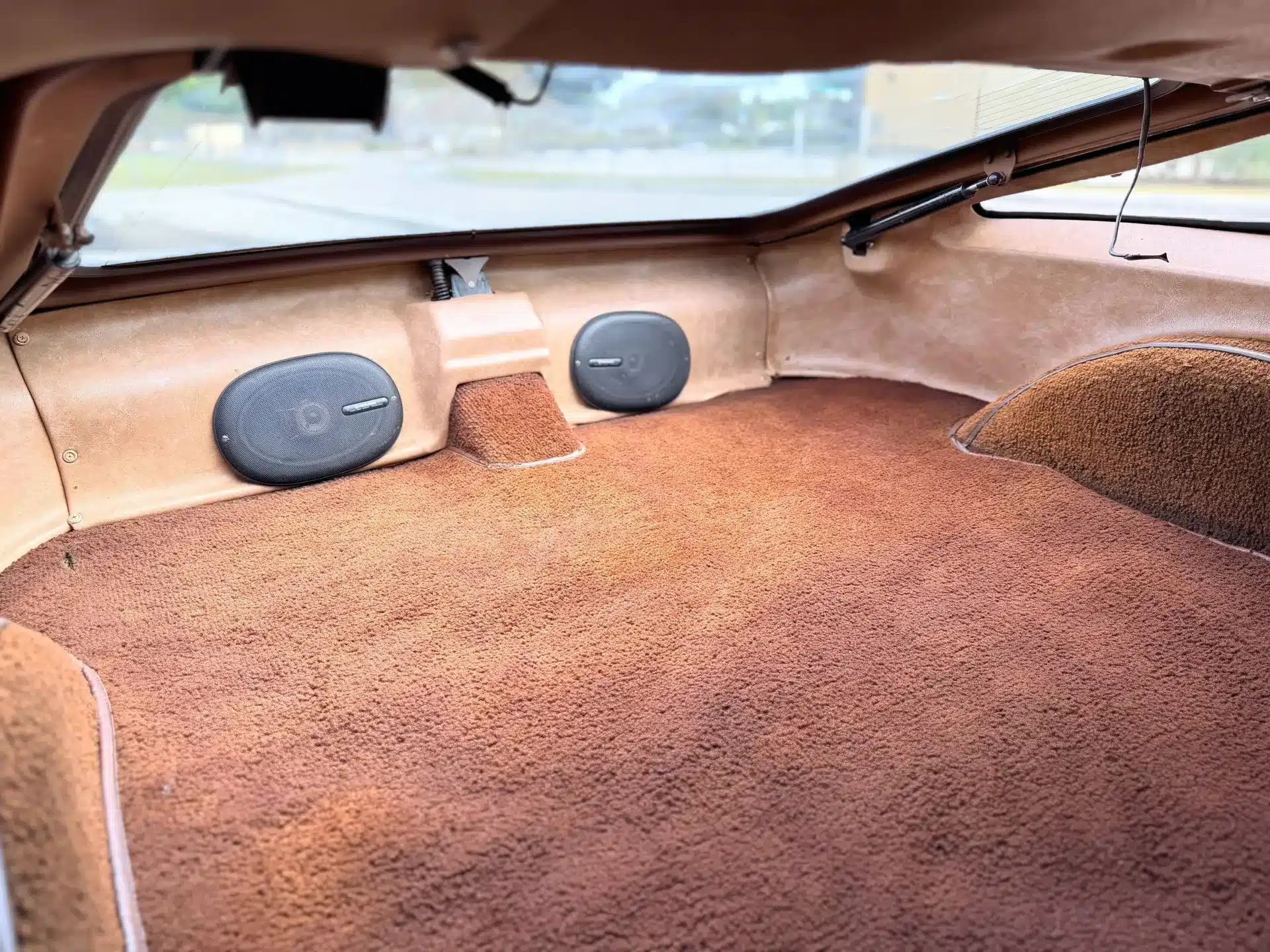 Kofferraum eines Bricklin SV-1 mit braunem Teppich und Lautsprechern.