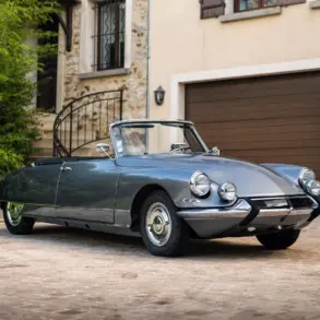Citroën DS21 Cabriolet aus dem Jahr 1966 in Grau, seitliche Frontansicht, geparkt vor einem Haus