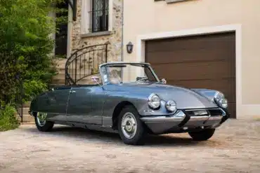 Citroën DS21 Cabriolet aus dem Jahr 1966 in Grau, seitliche Frontansicht, geparkt vor einem Haus