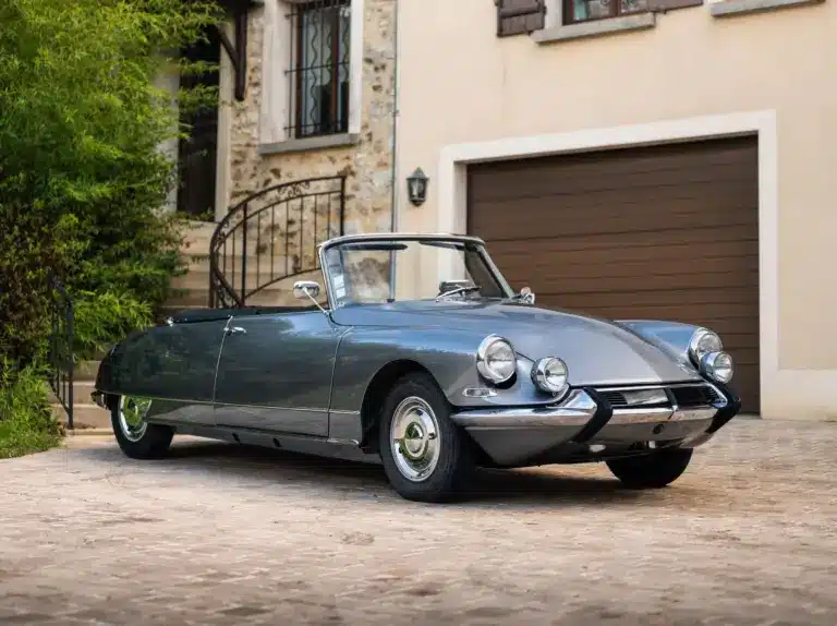 Citroën DS21 Cabriolet aus dem Jahr 1966 in Grau, seitliche Frontansicht, geparkt vor einem Haus