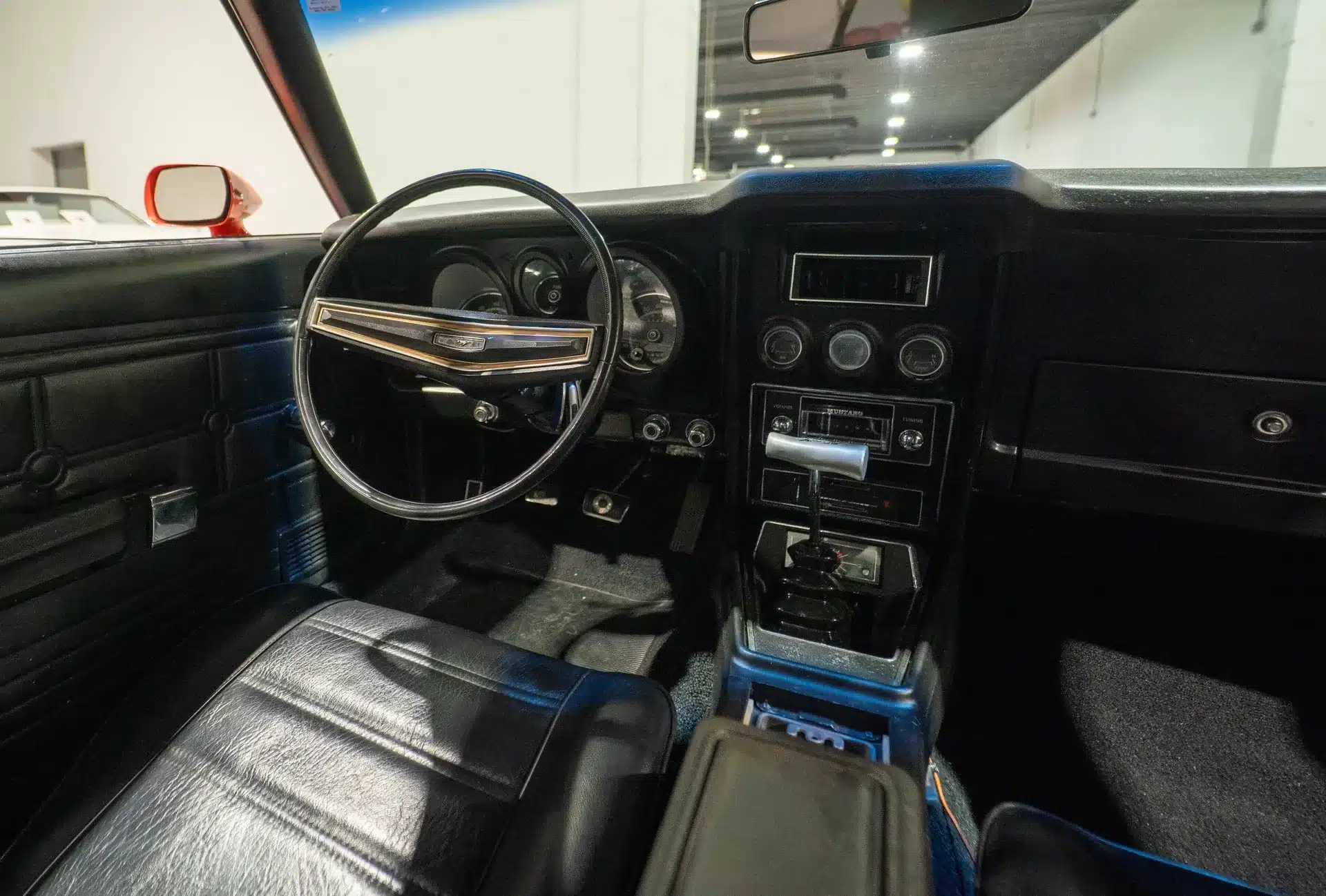 Innenraum und Cockpit eines Ford Mustang von 1971 mit schwarzer Lederausstattung und klassischem Armaturenbrett.