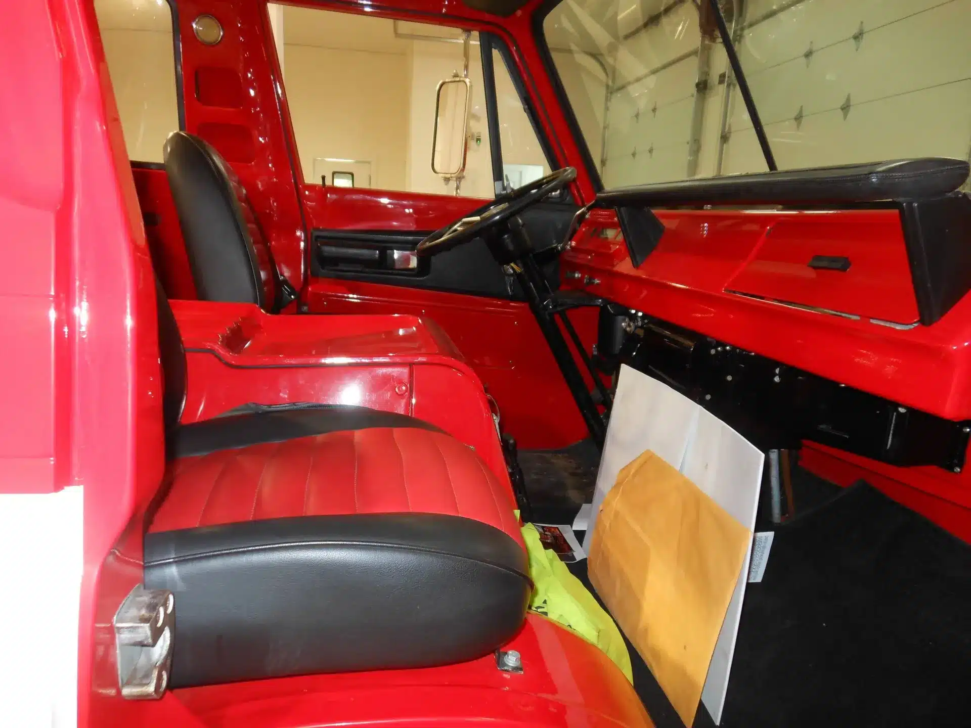 Restaurierter Innenraum eines roten Dodge A100 Pickups aus dem Jahr 1970 mit schwarzen und roten Sitzen