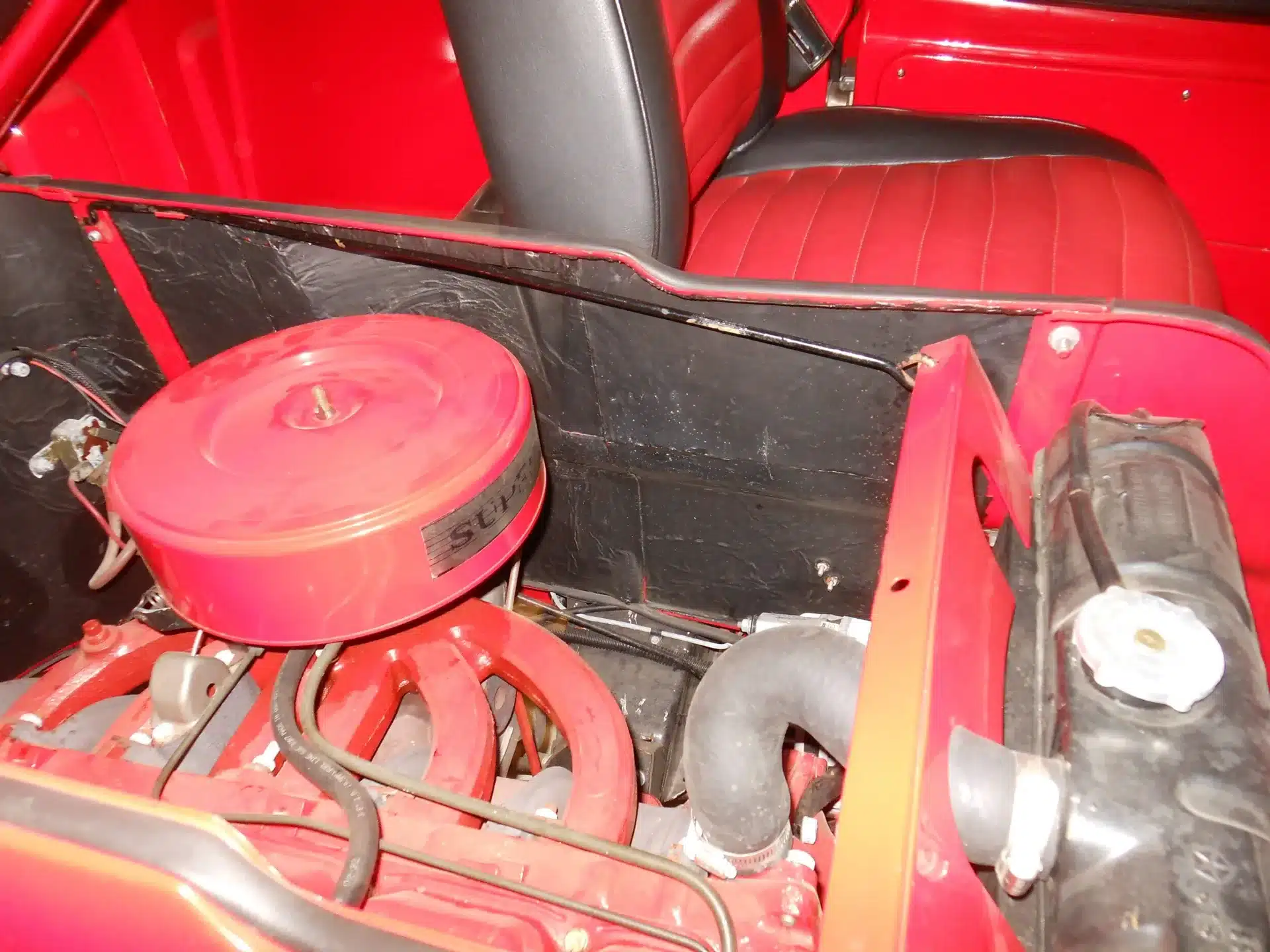 Restaurierter Motor und Sitzbereich eines Dodge A100 Pickup von 1970, Detailaufnahme von vorn.