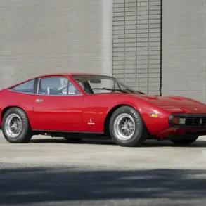 Roter Ferrari 365 GTC/4 aus dem Jahr 1972, geparkt vor einer Ziegelmauer.