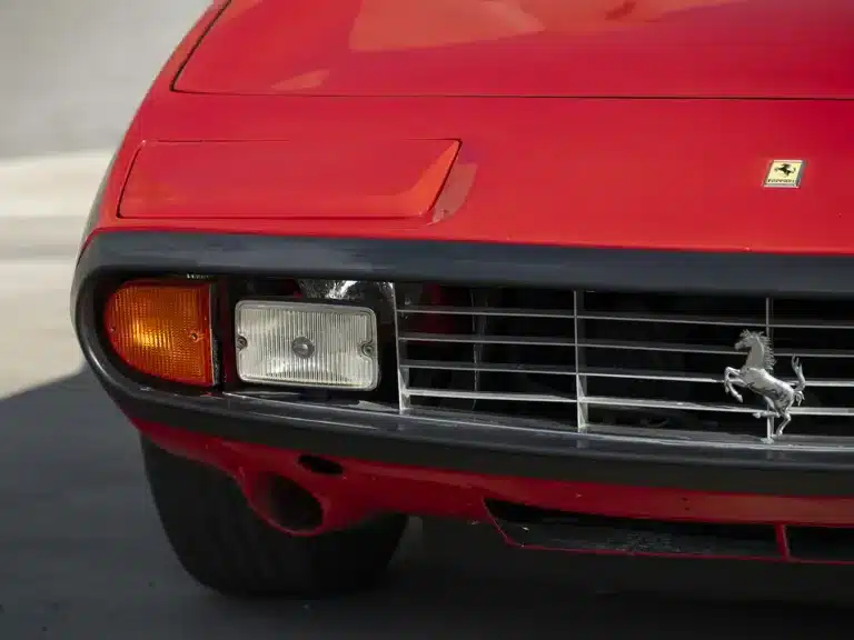 Frontansicht eines roten Ferrari 365 GTC/4 mit charakteristischem Grill, Klappscheinwerfern und Emblem.