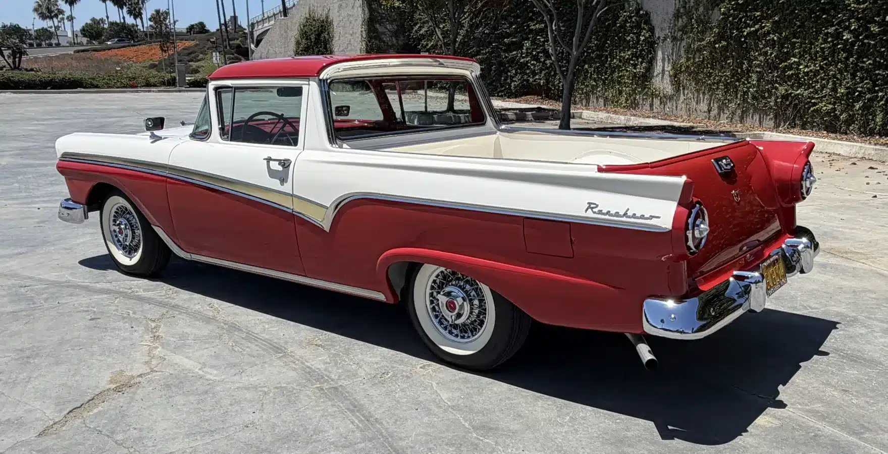 Seitenansicht eines restaurierten Ford Ranchero von 1957 in Rot und Weiß mit betonter Ladefläche.