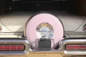 Heckpartie eines Mercury Monterey 1957 Coupé mit weißem und rosafarbenem Lack, Reserverad und verchromten Details.