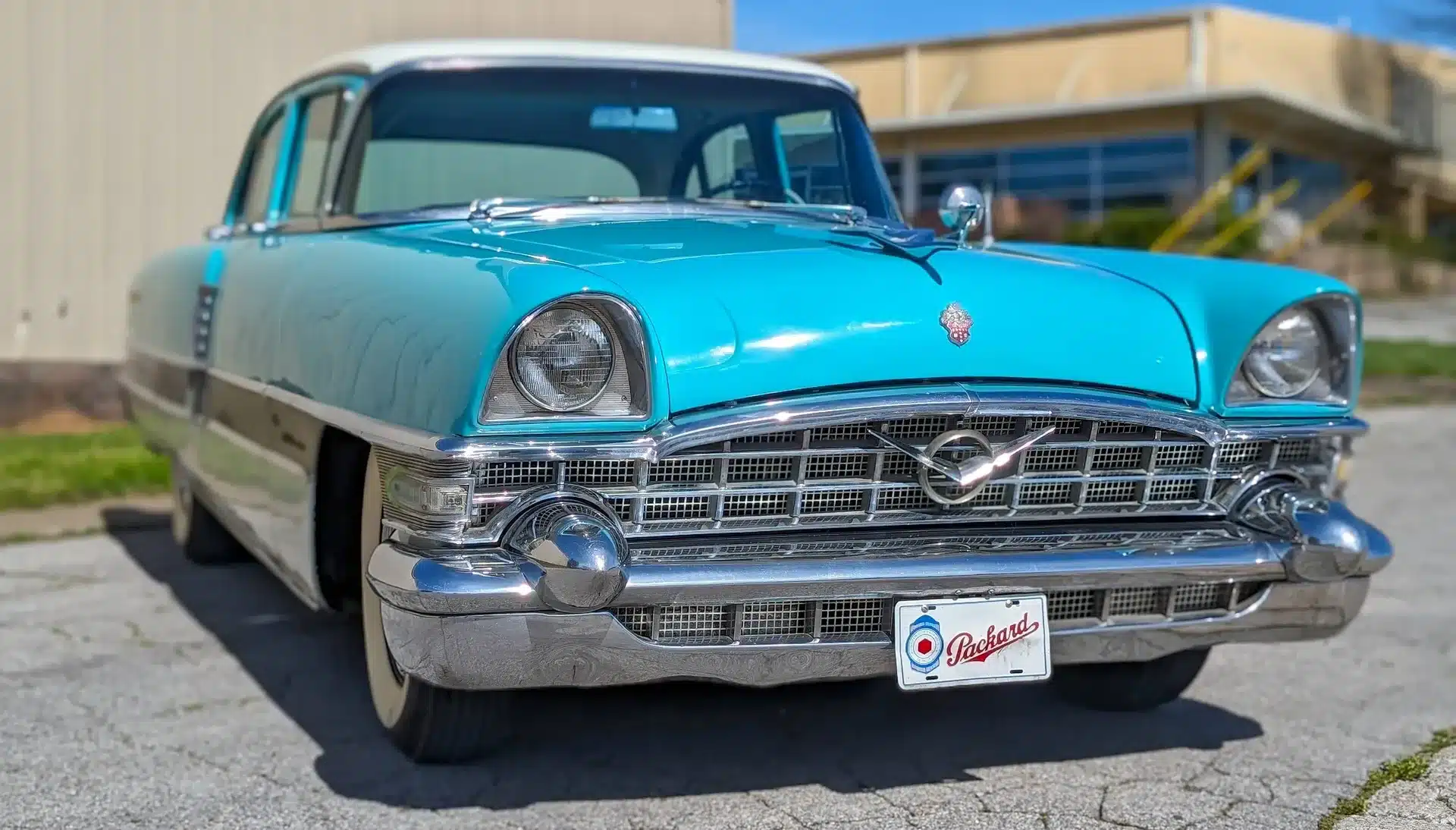 Frontansicht eines türkisfarbenen Packard Patrician von 1956 mit klassischen Chromdetails und markantem Kühlergrill.