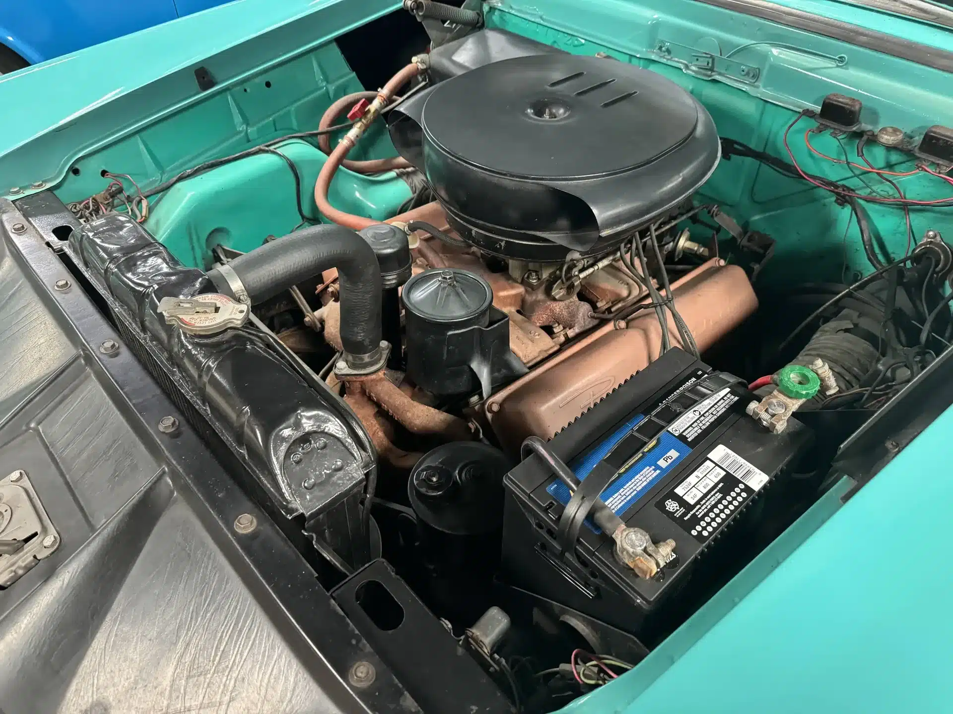 V8-Motor im türkisfarbenen Motorraum eines Packard Patrician von 1956