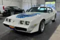 Pontiac Firebird Trans Am 1979, weiß, mit blauer Adler-Grafik, steht in einer Halle