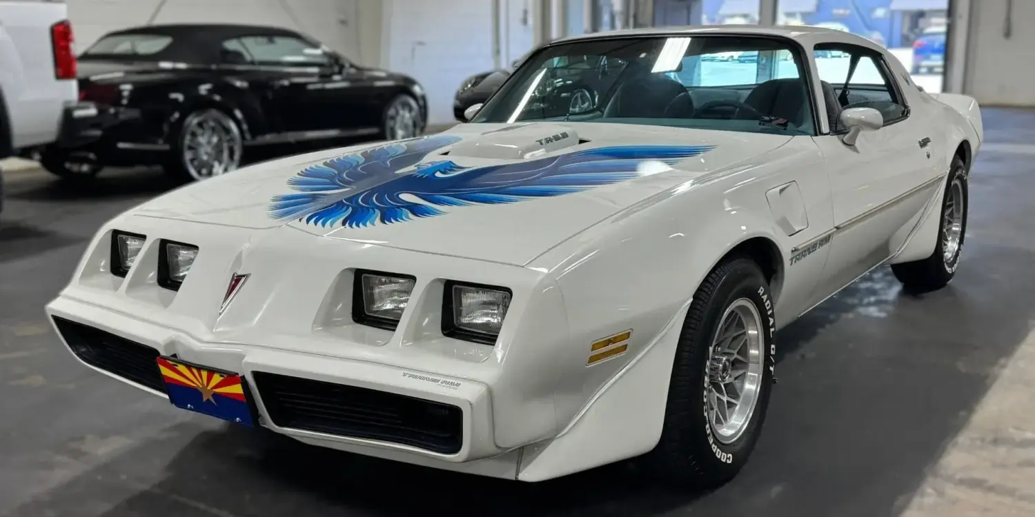 Pontiac Firebird Trans Am 1979, weiß, mit blauer Adler-Grafik, steht in einer Halle