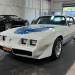 Pontiac Firebird Trans Am 1979, weiß, mit blauer Adler-Grafik, steht in einer Halle