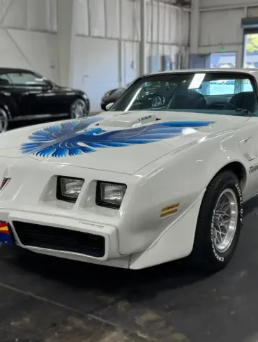 Pontiac Firebird Trans Am 1979, weiß, mit blauer Adler-Grafik, steht in einer Halle