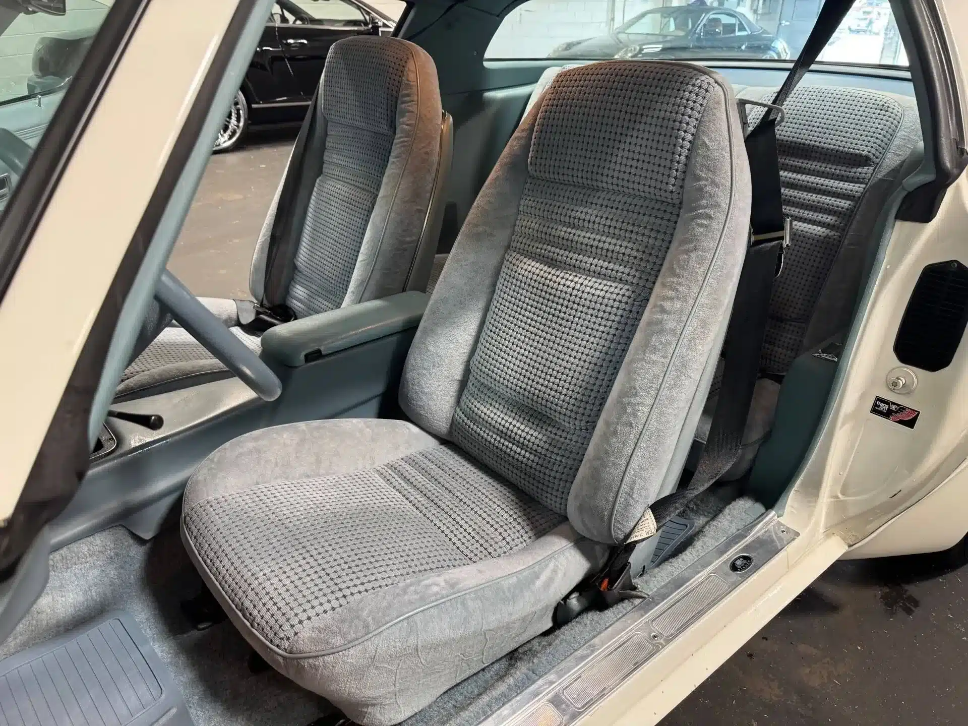 Innenraum eines Pontiac Firebird von 1979 mit grauen Sitzpolstern und klassischen Armaturen.
