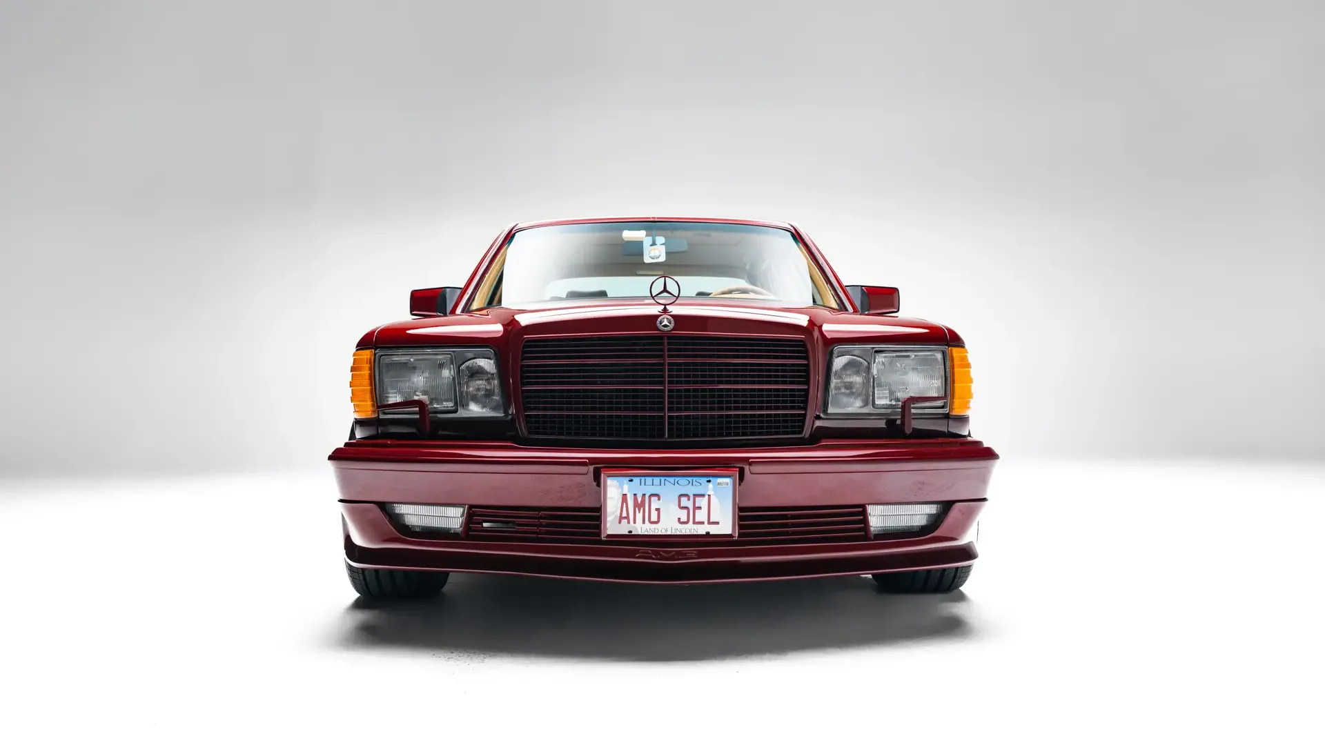 Frontansicht eines roten Mercedes-Benz 500 SEL 6.0 AMG W126 mit AMG-Aero-I-Rädern und Illinois-Kennzeichen AMG SEL.