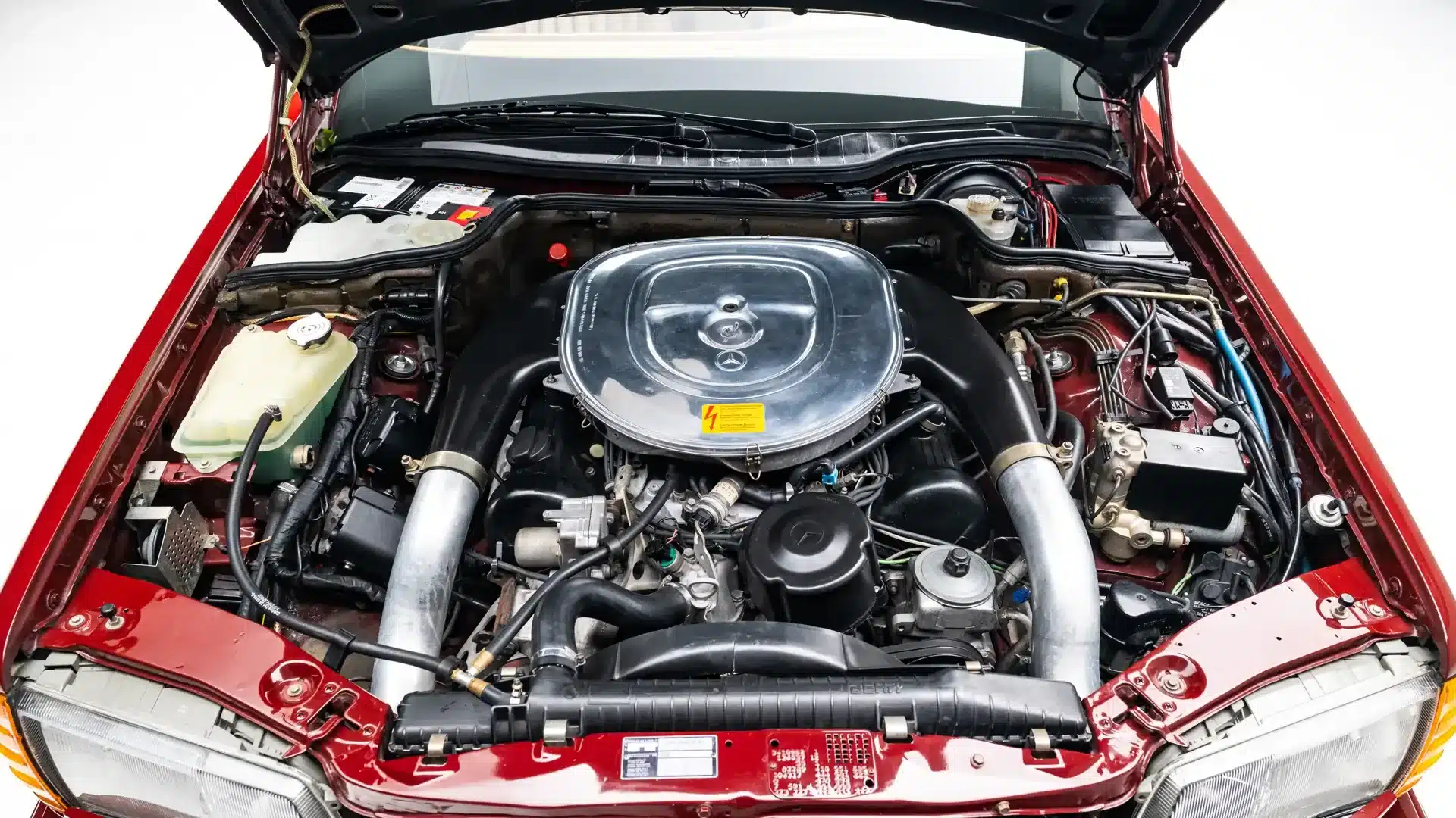 Motorraum eines restaurierten Mercedes-Benz 500 SEL 6.0 AMG von 1983 mit AMG-Spezialumbauten.
