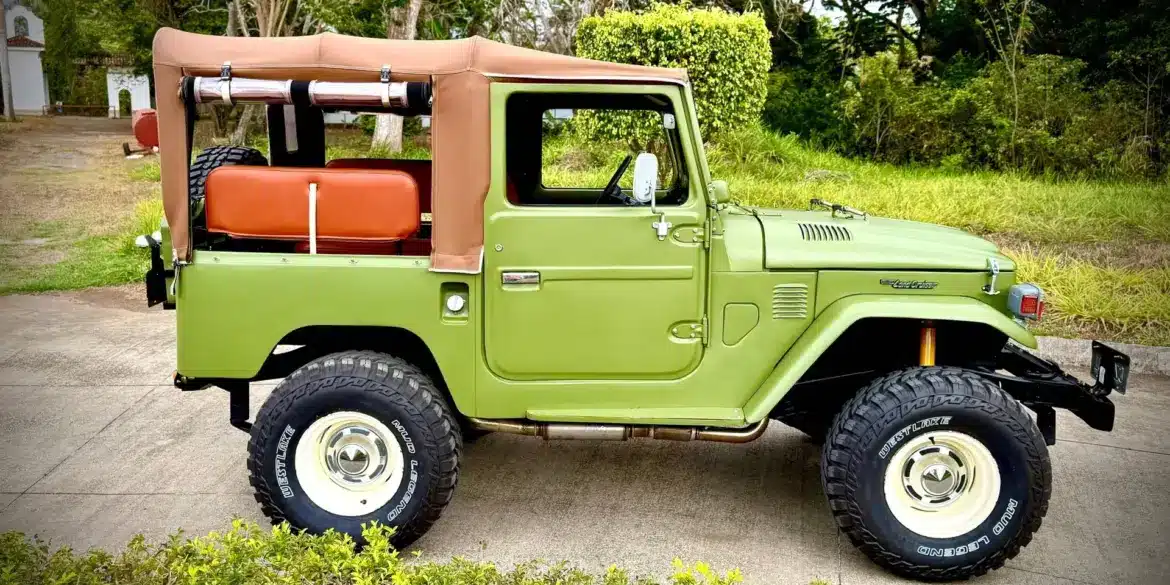 Toyota Land Cruiser von 1978 in Grün mit Softtop, klassische Geländewagen-Optik, auf einem Außengelände geparkt.