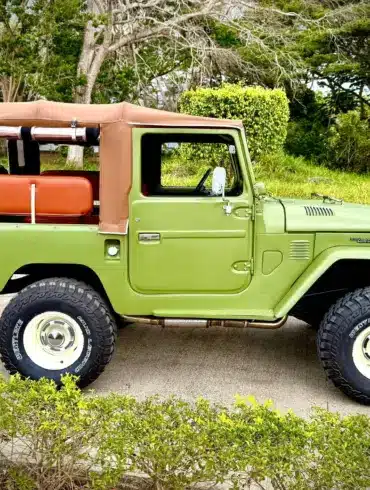 Toyota Land Cruiser von 1978 in Grün mit Softtop, klassische Geländewagen-Optik, auf einem Außengelände geparkt.