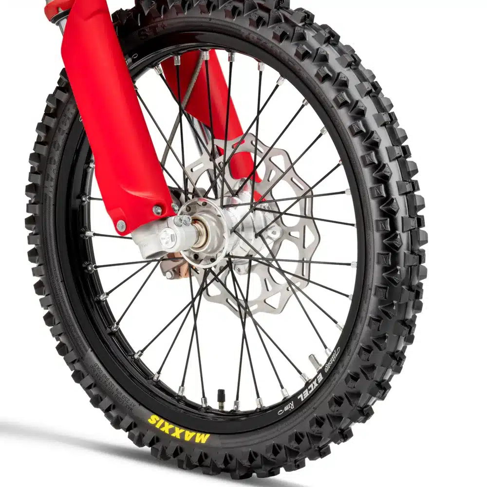 Detailfoto des Vorderrads mit grobstolligem Maxxis-Reifen, Scheibenbremse und WP-Federung an der GasGas MC 85 19/16.