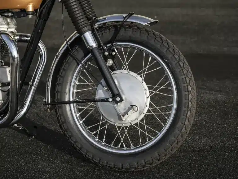Vorderes Laufrad mit Edelstahlkotflügel und grobstolligem Reifen an der Triumph Bonneville TT Special von 1967