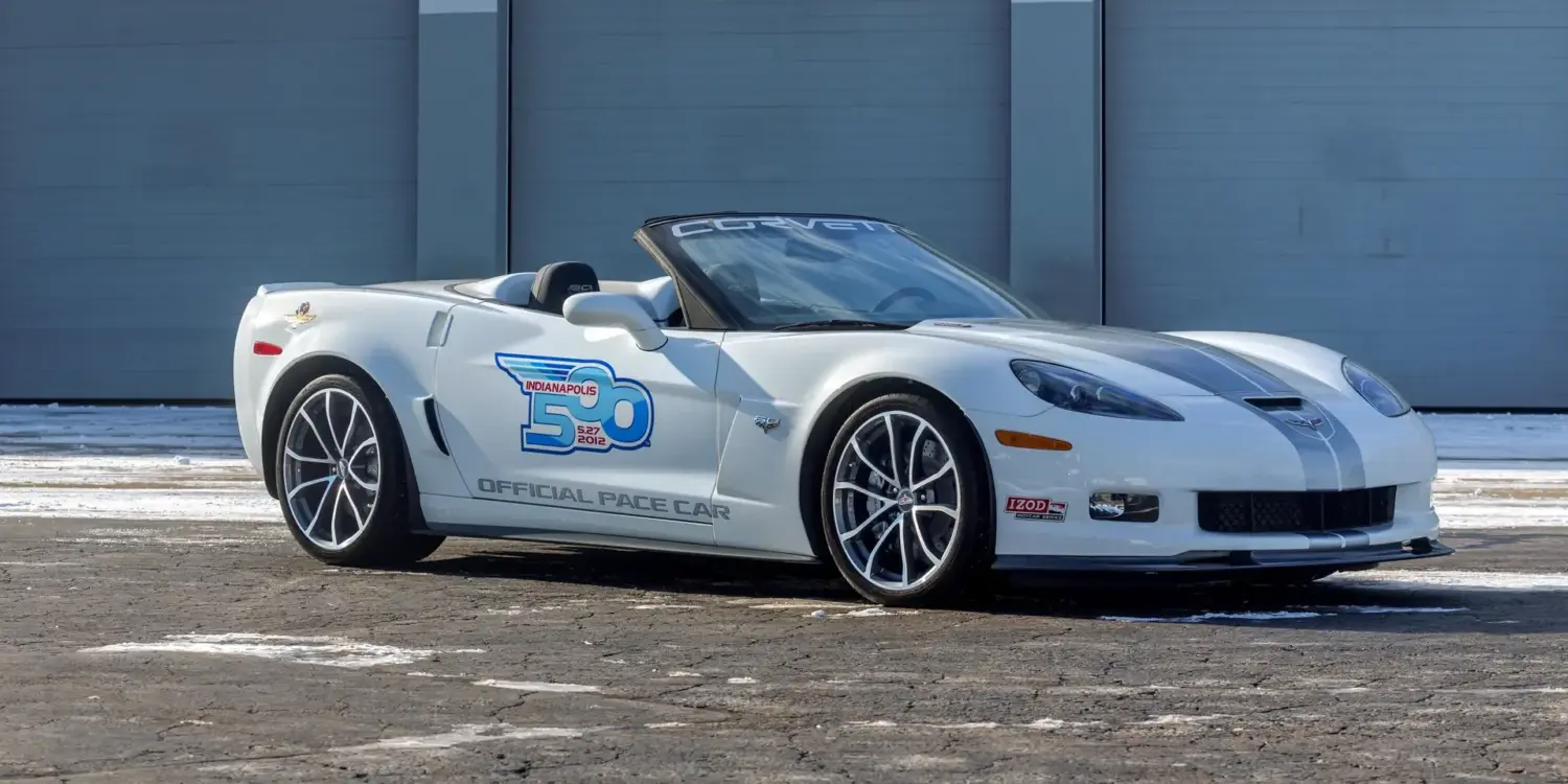 Weiße Chevrolet Corvette 427 Convertible Collector Edition 60th Anniversary Indianapolis 500 Pace Car von 2013, Seitenansicht vor einer Garage.
