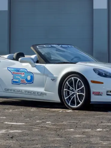 Weiße Chevrolet Corvette 427 Convertible Collector Edition 60th Anniversary Indianapolis 500 Pace Car von 2013, Seitenansicht vor einer Garage.