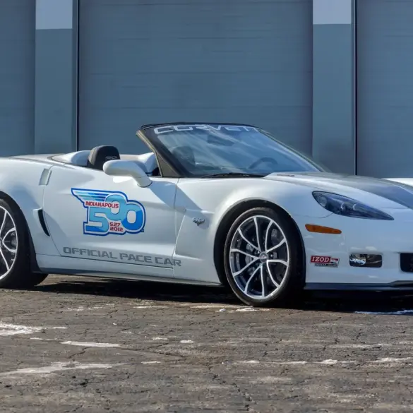 Weiße Chevrolet Corvette 427 Convertible Collector Edition 60th Anniversary Indianapolis 500 Pace Car von 2013, Seitenansicht vor einer Garage.