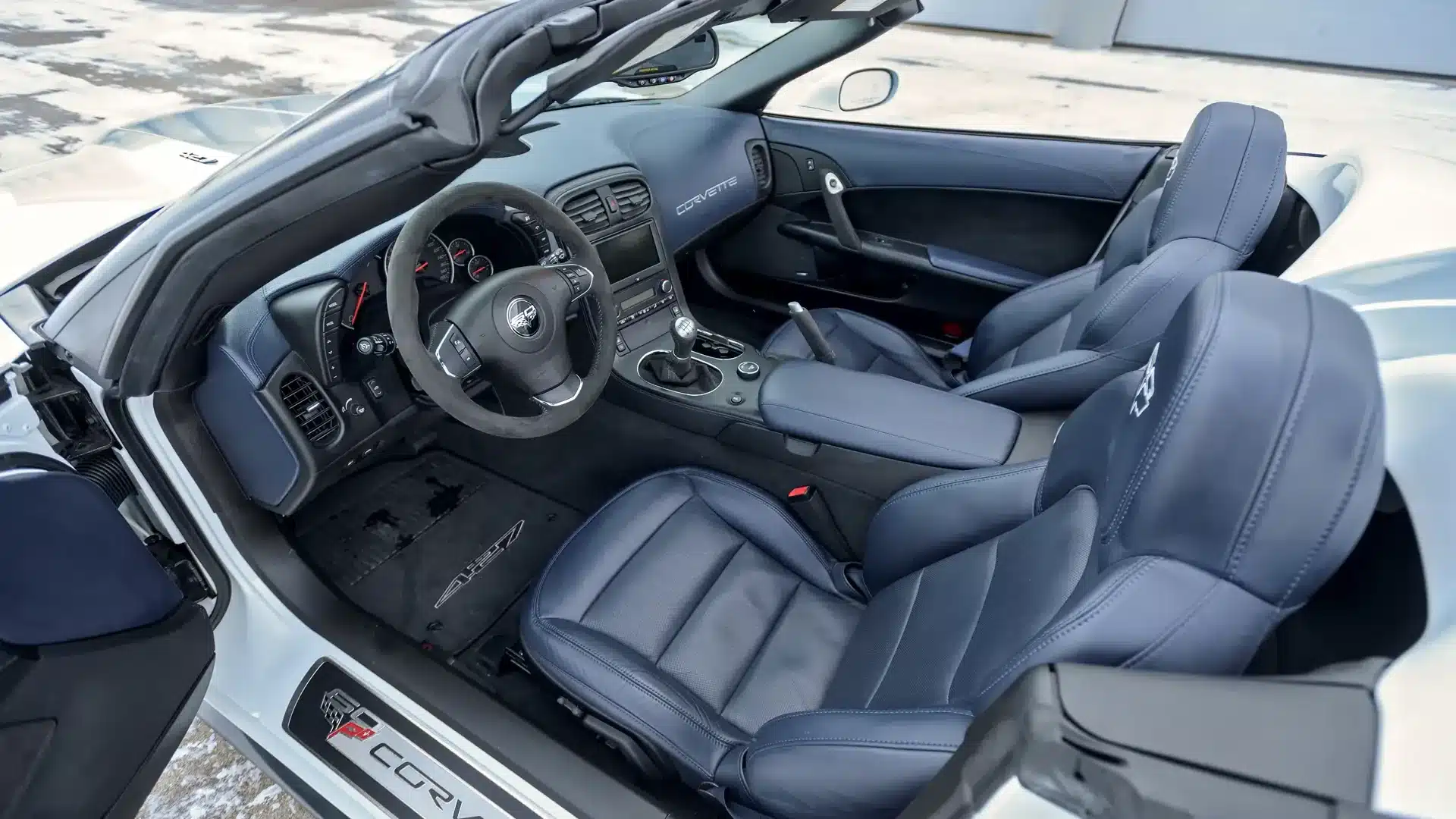 Blick in den Innenraum einer Chevrolet Corvette 427 Convertible Collector Edition mit blauen Ledersitzen und Cabrioverdeck.