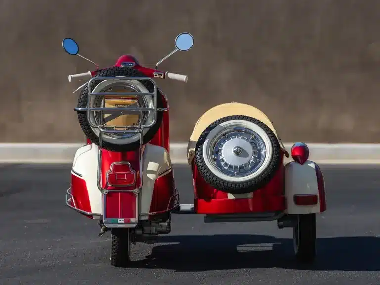 Restaurierte Vespa 150 Super mit Beiwagen, Baujahr 1966, in Rot-Weiß, von hinten fotografiert.