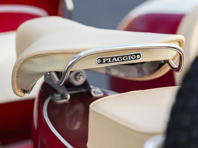 Detailaufnahme des cremefarbenen Sattels einer Piaggio Vespa 150 Super, Baujahr 1966, mit sichtbarem PIAGGIO-Schild.