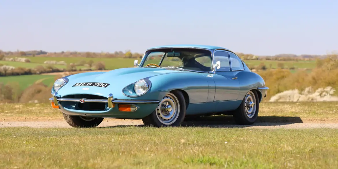 Jaguar E-Type 4.2 Series 2 Fixed Head Coupé von 1969 in Light Blue auf einer Wiese