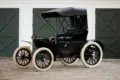 Duryea Four Wheel Phaeton von 1905 mit offener Karosserie und weißen Reifen vor Toren