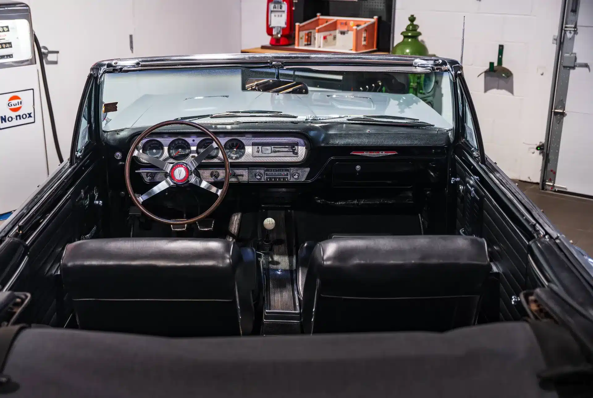 Blick auf das Cockpit und Lenkrad eines Pontiac GTO von 1964 mit klassischem Armaturenbrett