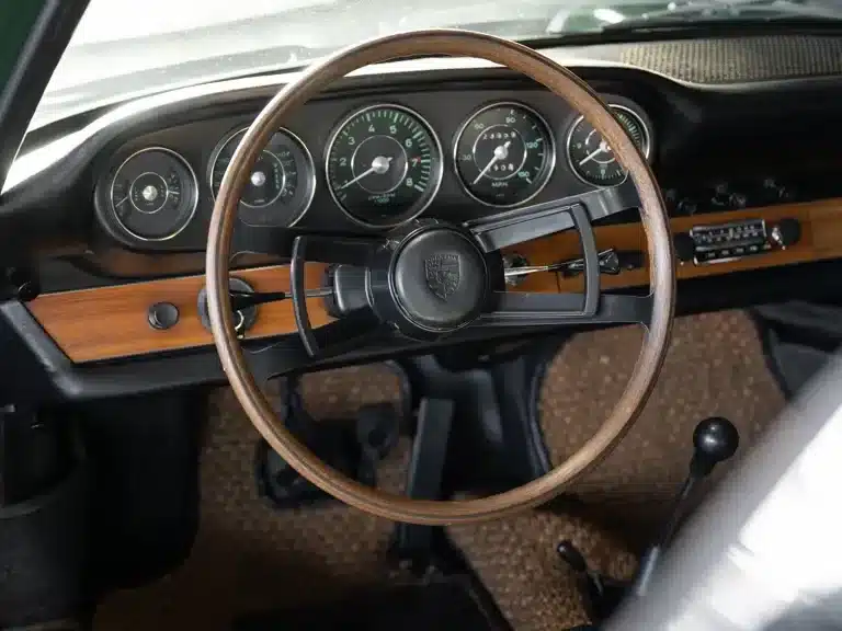 Blick auf das Cockpit eines unrestaurierten Porsche 911 Coupé von 1966 mit Holzlenkrad und klassischem Armaturenbrett