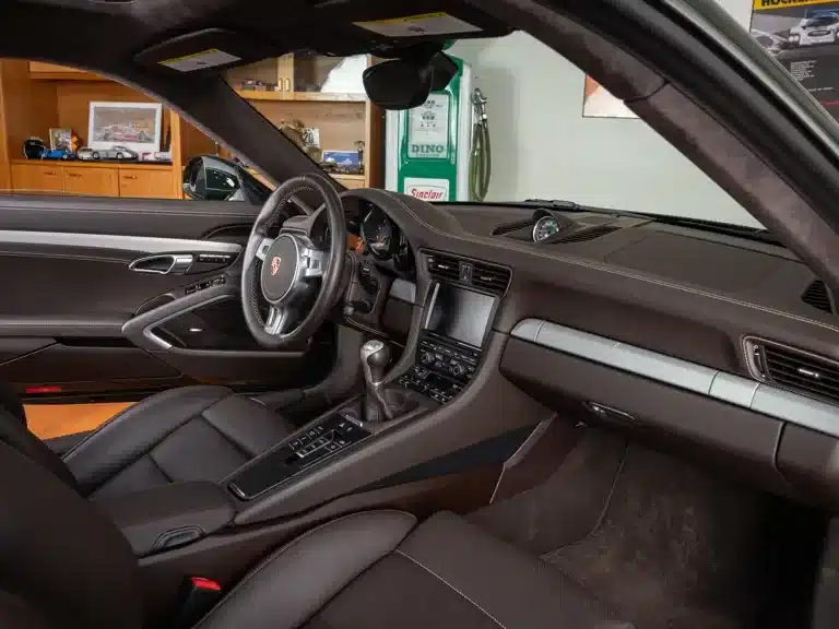Innenaufnahme des Porsche 911 Carrera S Club Coupé von 2013 mit manuellem 7-Gang-Schaltgetriebe und braunem Lederinterieur.