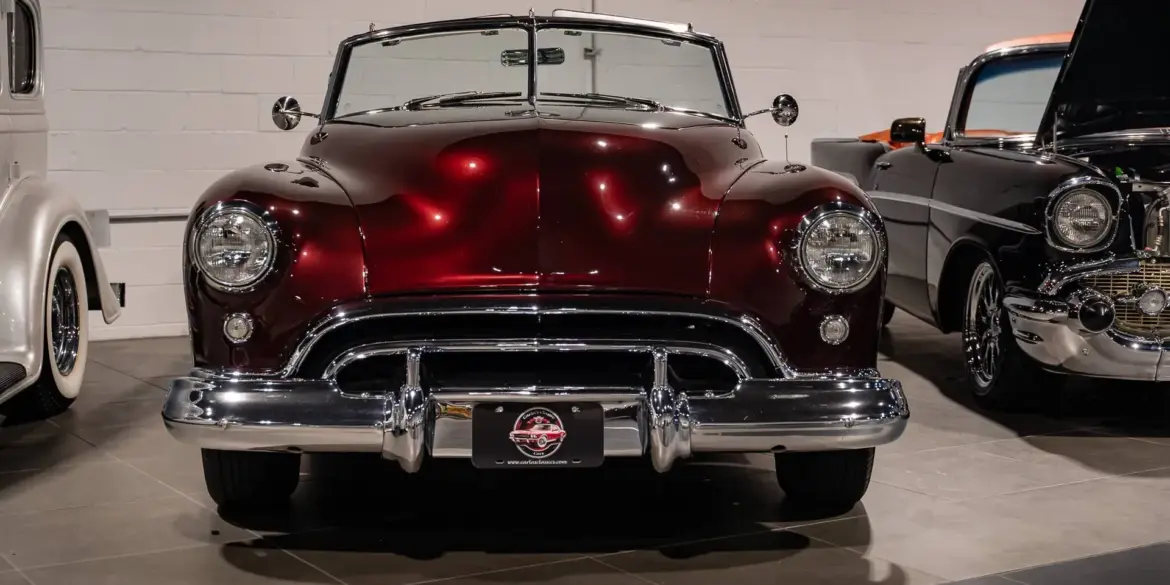 Burgunderroter Oldsmobile 88 Convertible von 1948, frontal aufgenommen, mit Chromverzierungen und hellem Innenraum.