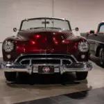 Burgunderroter Oldsmobile 88 Convertible von 1948, frontal aufgenommen, mit Chromverzierungen und hellem Innenraum.