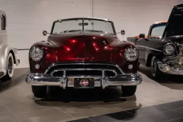 Burgunderroter Oldsmobile 88 Convertible von 1948, frontal aufgenommen, mit Chromverzierungen und hellem Innenraum.