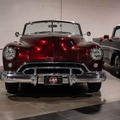 Burgunderroter Oldsmobile 88 Convertible von 1948, frontal aufgenommen, mit Chromverzierungen und hellem Innenraum.