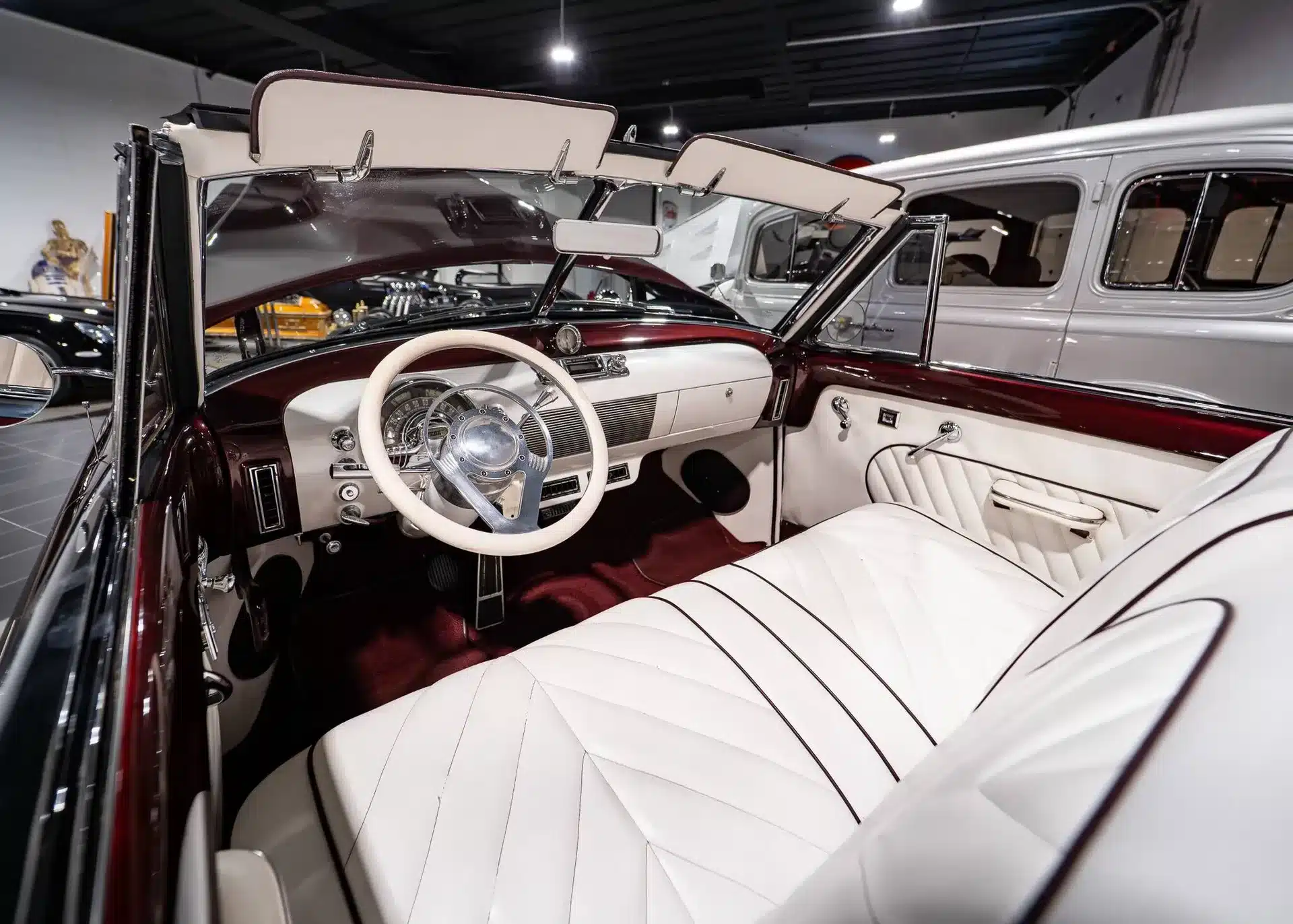 Innenansicht eines Oldsmobile 88 Cabriolet von 1948 mit weißem Leder und burgunderrotem Armaturenbrett.