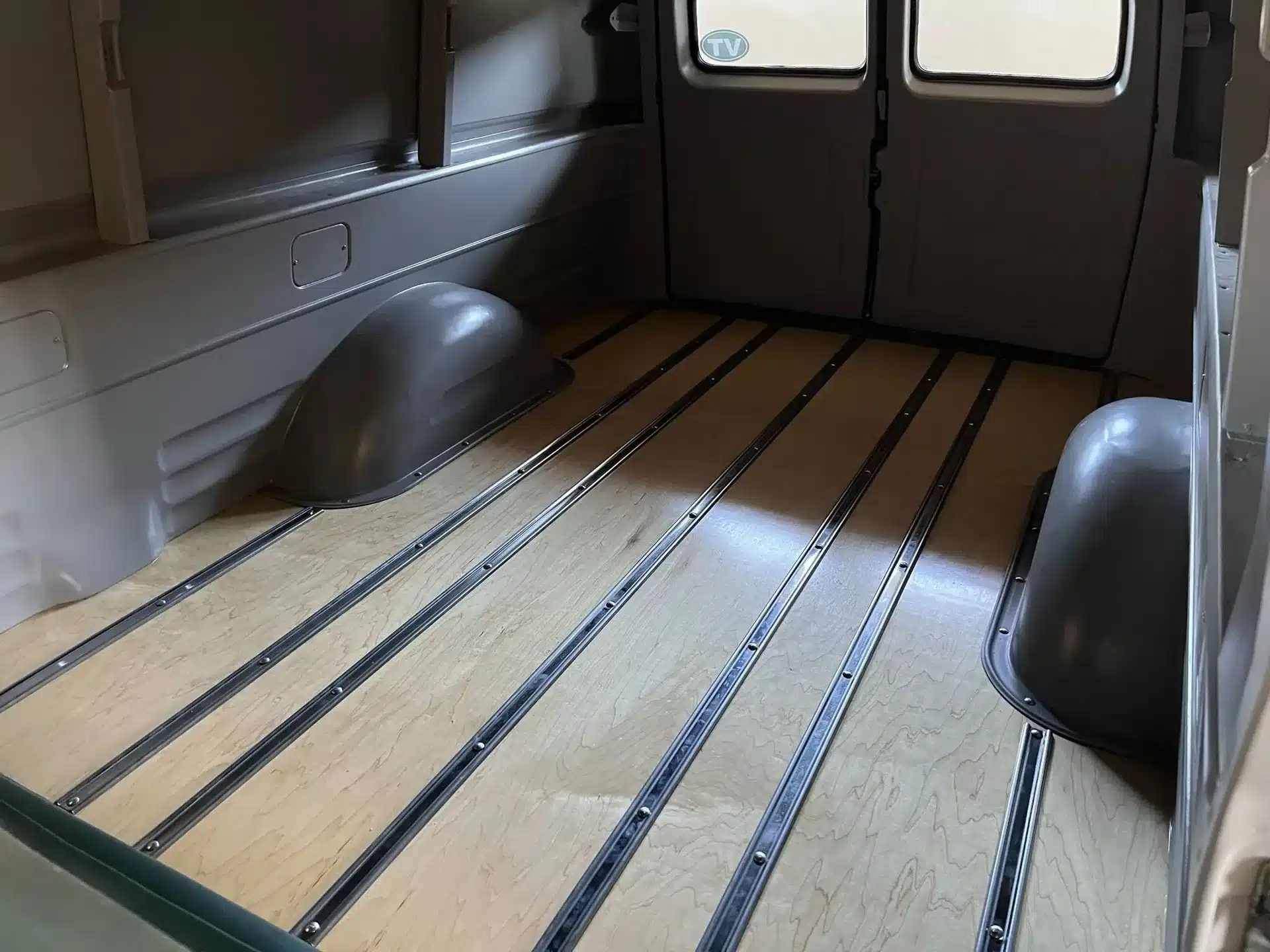 Restaurierter Laderaum eines 1956er Chevrolet 3100 Panel Truck mit Holzfußboden und sichtbaren Radkästen