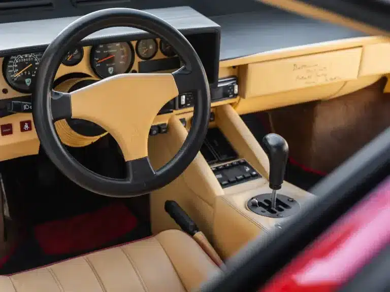 Innenraum eines Lamborghini Countach 25th Anniversary Edition mit beigem Leder, sportlichem Lenkrad und klassischem Schaltknauf.