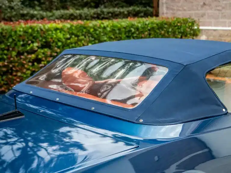 Blick auf das Stoffverdeck und Interieur eines zweifarbigen Ferrari 365 GTB/4 Daytona NART Spider by Michelotti, mit oranger Lederausstattung.