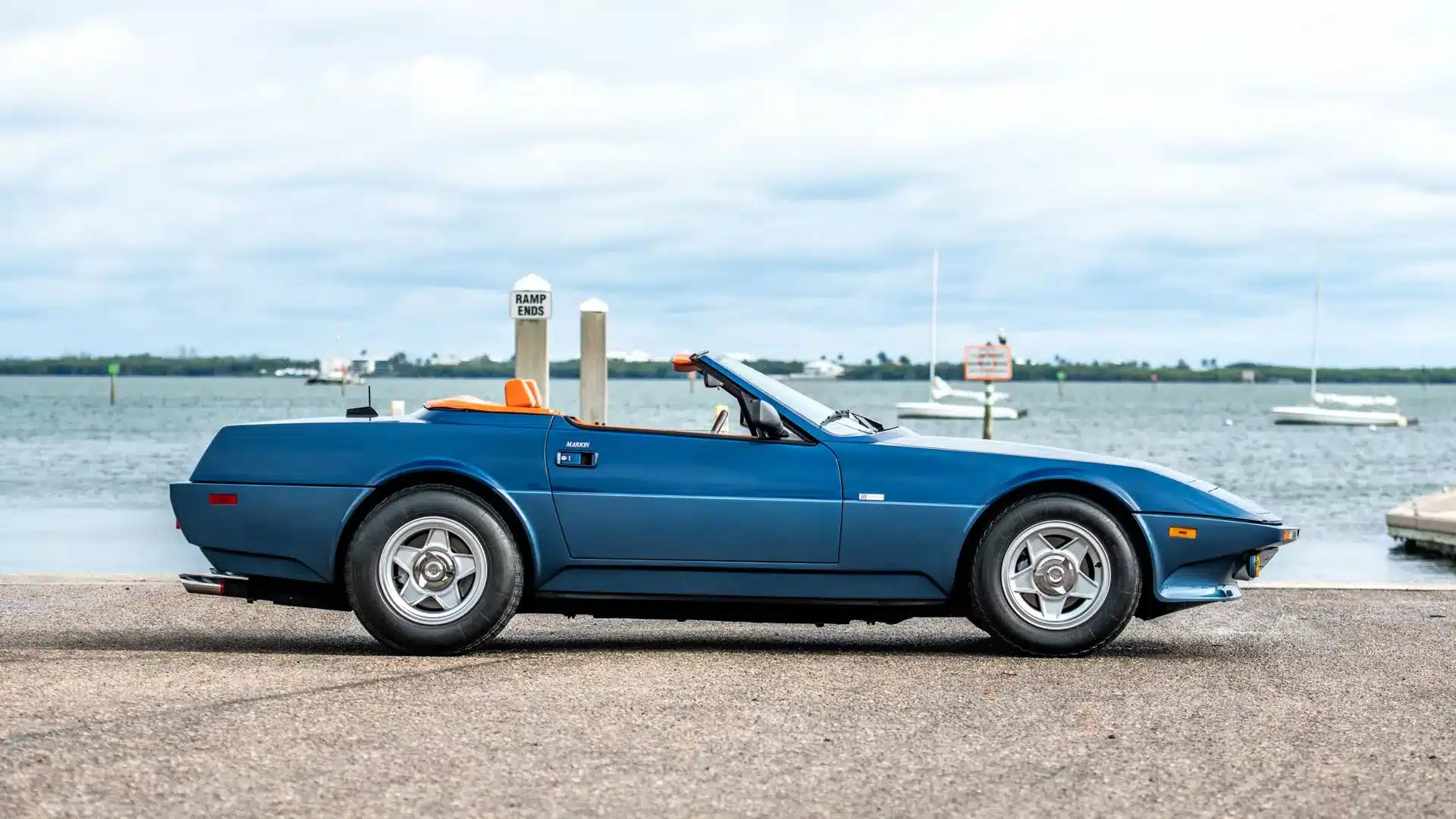 Seitenansicht des blauen Ferrari 365 GTB/4 Daytona NART Spider by Michelotti aus dem Jahr 1971 mit offenem Verdeck und orangefarbenem Interieur.