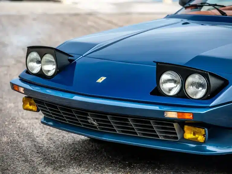 Detailaufnahme der Front des blauen Ferrari 365 GTB/4 Daytona NART Spider by Michelotti, Scheinwerfer ausgeklappt.