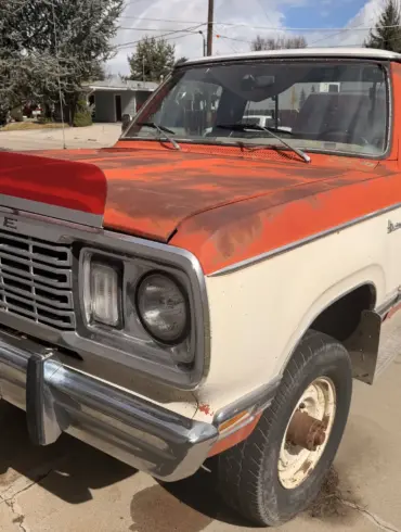 Dodge 200 Pickup von 1978 in rot-weißer Lackierung, stehend auf einer Einfahrt.