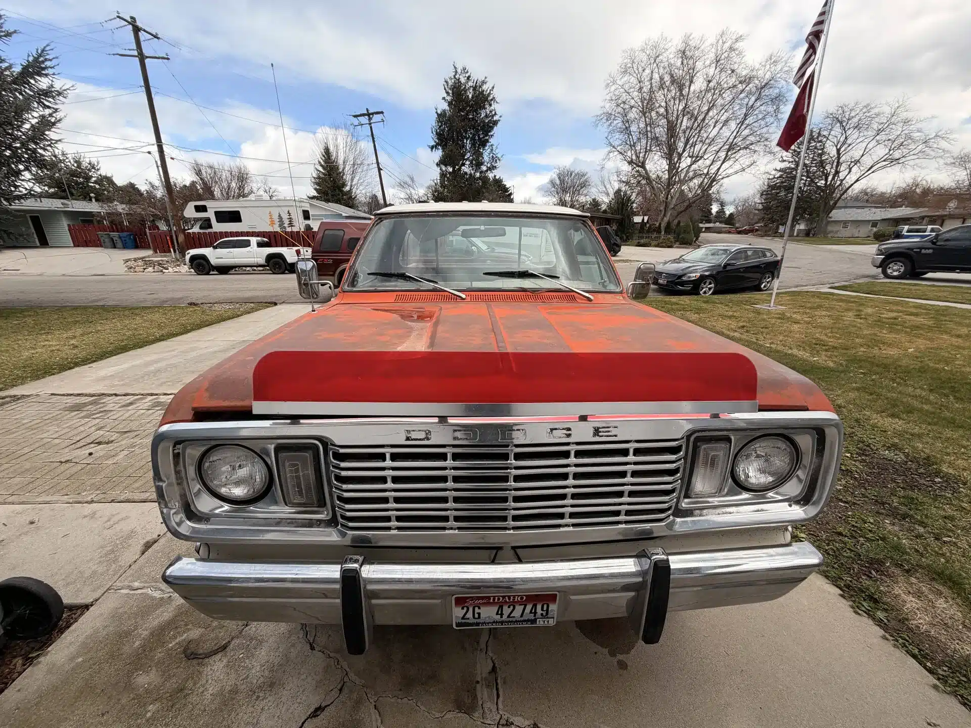 Frontansicht eines rot-orangenen Dodge 200 Pick-ups aus dem Jahr 1978 auf einer Einfahrt