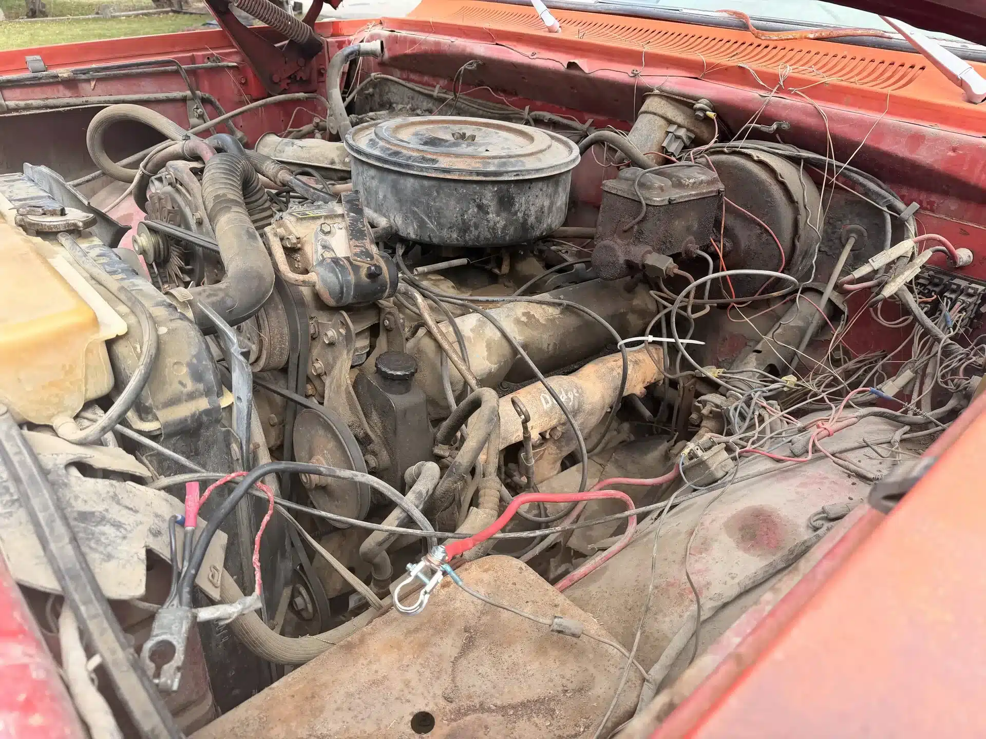 Blick in den Motorraum eines alten Dodge 200 mit sichtbaren Gebrauchsspuren und Verkabelung