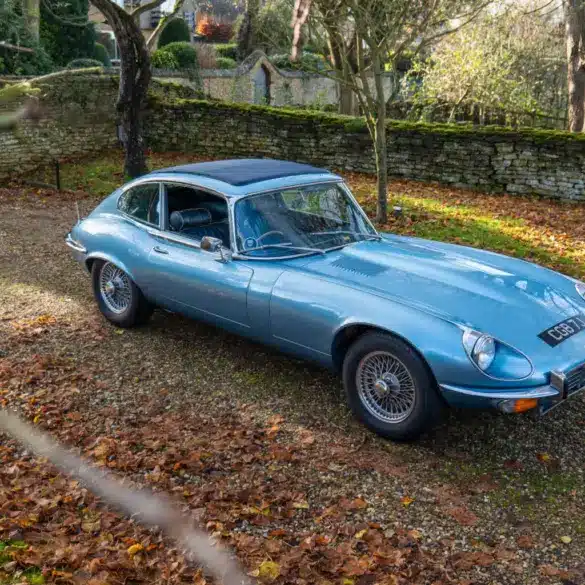 Jaguar E-Type Serie 1 4.2 Fixed Head Coupé 1965 in Opalescent Silver Blue, geparkt im Freien auf einem mit Laub bedeckten Kiesweg.