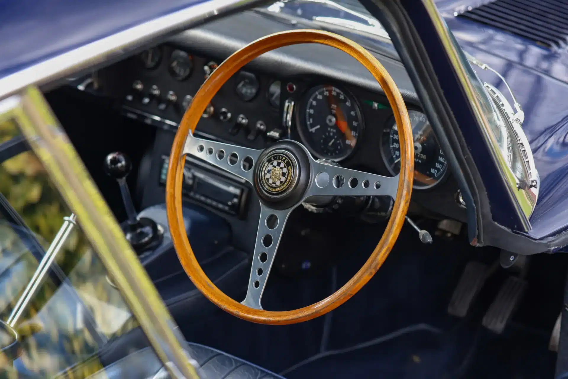 Blick auf das originale Holzlenkrad und die Armaturentafel eines Jaguar E-Type Series 1 4.2 Fixed Head Coupé von 1965